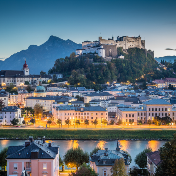 Vista de Salzburgo al atardecer con la fortaleza Hohensalzburg y el río Salzach.