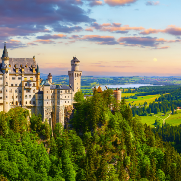 Castillo de Neuschwanstein rodeado de bosques y paisajes verdes en Baviera.